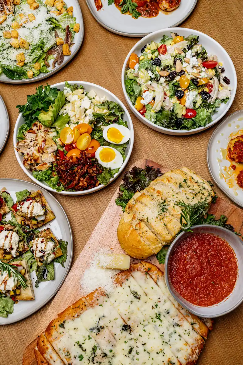 A table of salads, pasta and flatbread to share at Jasper’s
