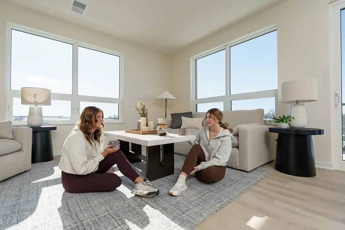 Two residents relaxing in a furnished apartment at Monarch on Main